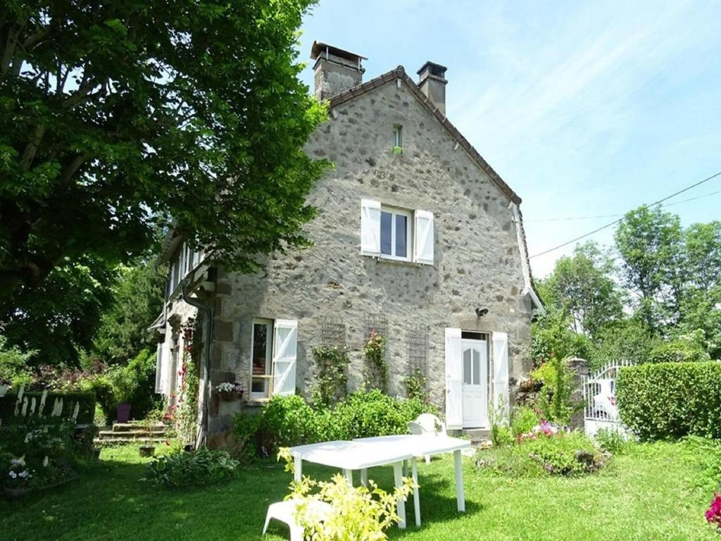 a stone house with a picnic table in front of it at Cottage in Auvergne near Puy Mary in LʼHôpital