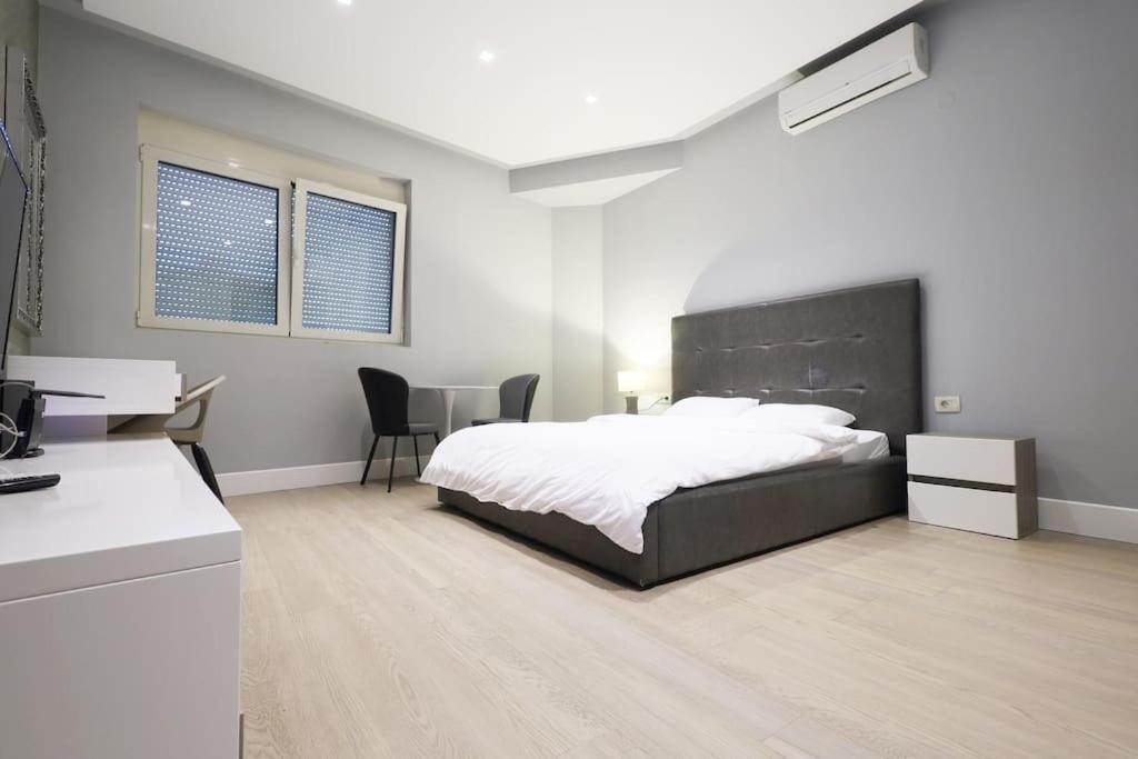 a bedroom with a large bed and a desk at Stylish modern studio in Budva with a sea view in Budva
