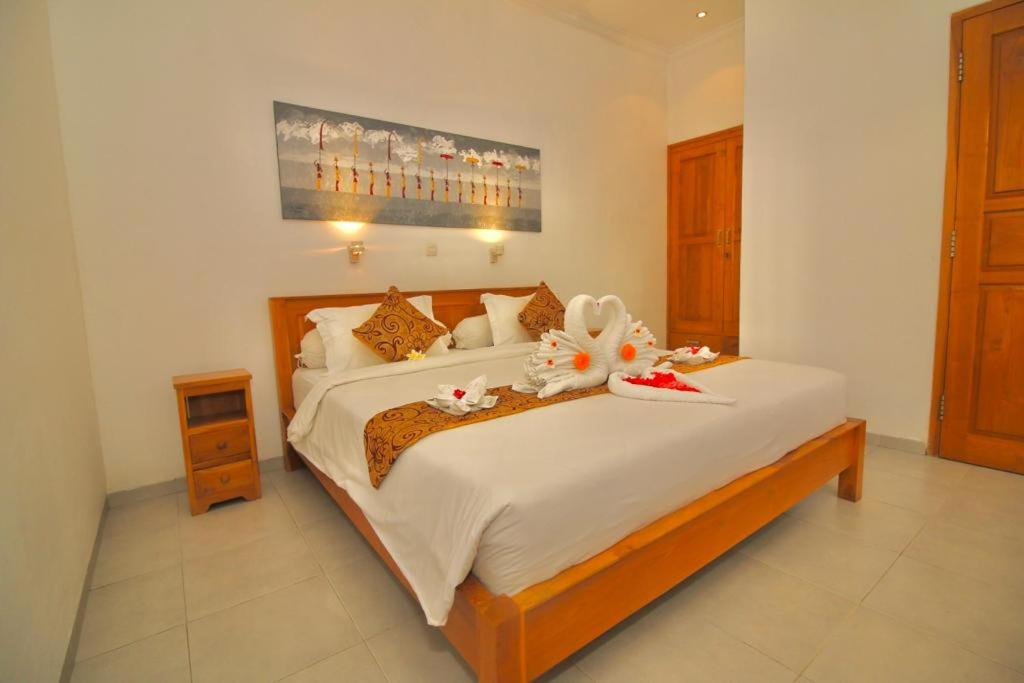 a bedroom with a large bed with flowers on it at Villa Seruni Lovina in Lovina