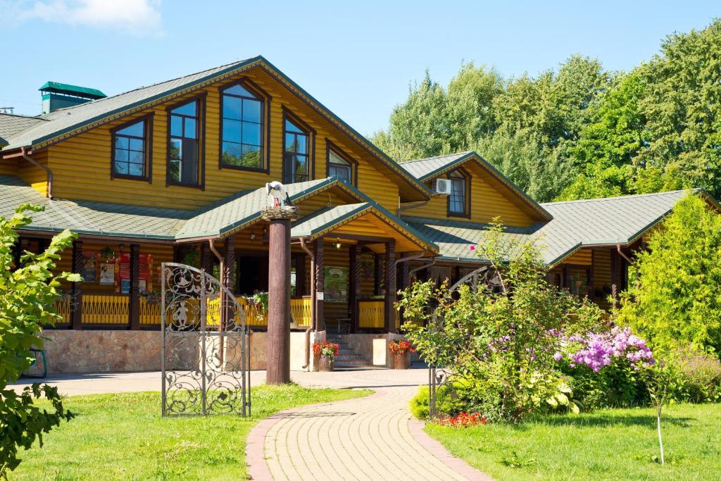 una gran casa de madera con un camino delante de ella en Yuryevskoye Podvorye Boutique Hotel, en Velikiy Novgorod