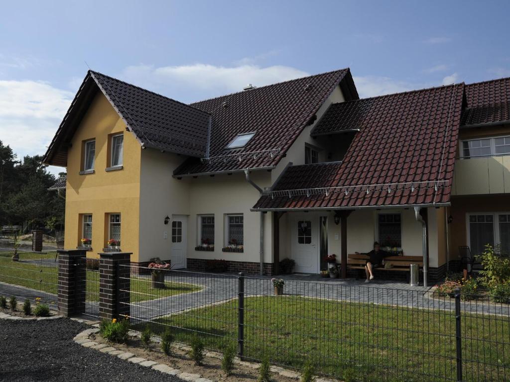 una casa con techos marrones y una valla en 2-room apartment in Lübben in the Spreewald en Lübben
