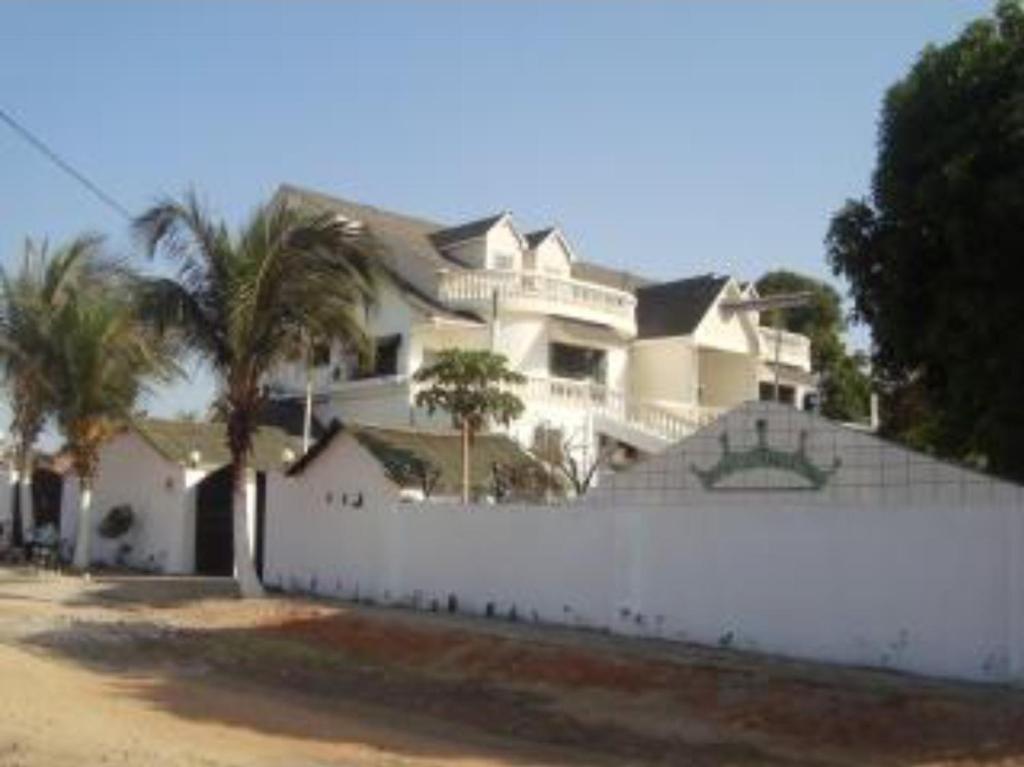 a large white house behind a white fence at #4 princess self catering apartments, Senegambia area in Sere Kunda