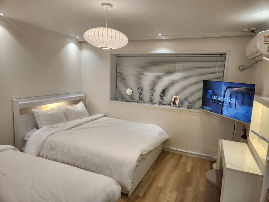 - une chambre avec 2 lits et une télévision à écran plat dans l'établissement NEW OPEN-Oublier,SEOUL STN 5min by walk,Cozy Home, à Séoul