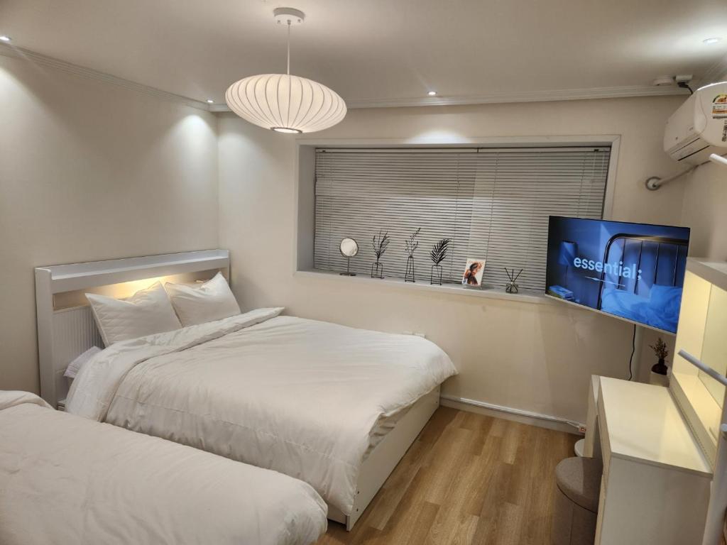 een slaapkamer met twee bedden en een flatscreen-tv bij NEW OPEN-Oublier,SEOUL STN 5min by walk,Cozy Home in Seoul
