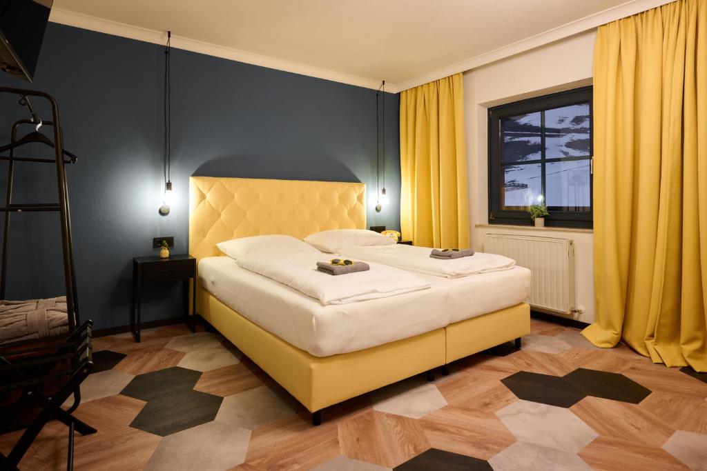 a bedroom with a large bed with yellow curtains at Boutique House happYellow - incl Joker Card in summer in Saalbach Hinterglemm