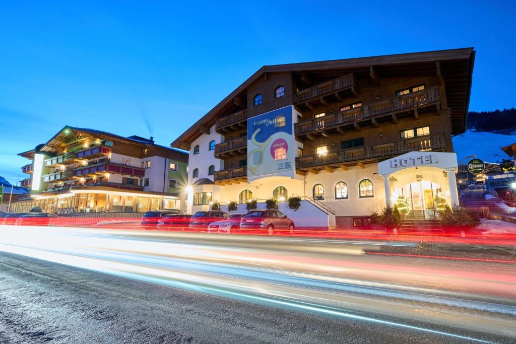 a building with cars parked in front of a street at happYellow Boutique House in Saalbach Hinterglemm