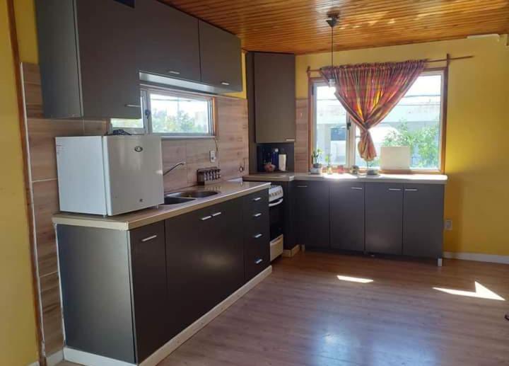 a large kitchen with a refrigerator and a window at Domuyo 3 in Neuquén