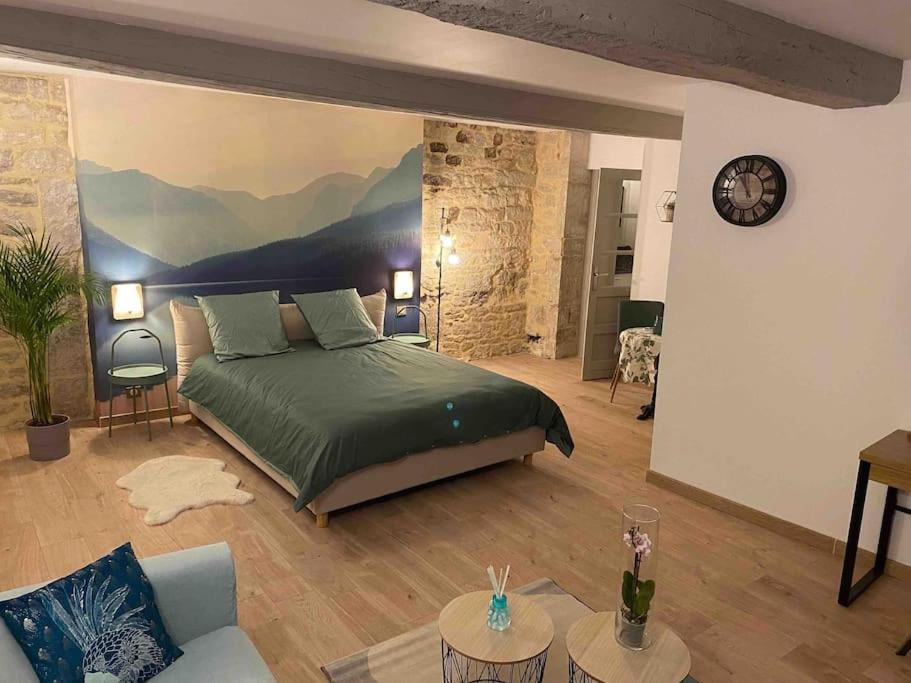 sypialnia z łóżkiem i kanapą w pokoju w obiekcie Nuits centre : superbe gîte rénové et climatisé w mieście Nuits-Saint-Georges