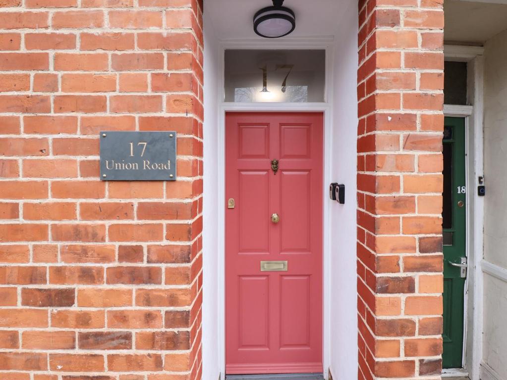 a red door on a brick building with a brick wall at 17 Union Road Basement in Lincoln