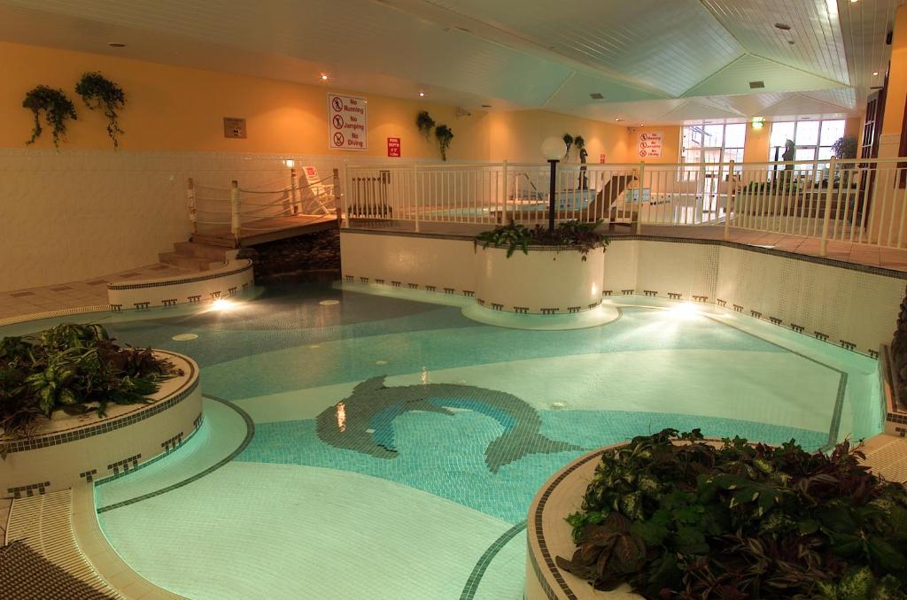 a large indoor swimming pool with a dolphin in a building at Dingle Skellig Hotel in Dingle