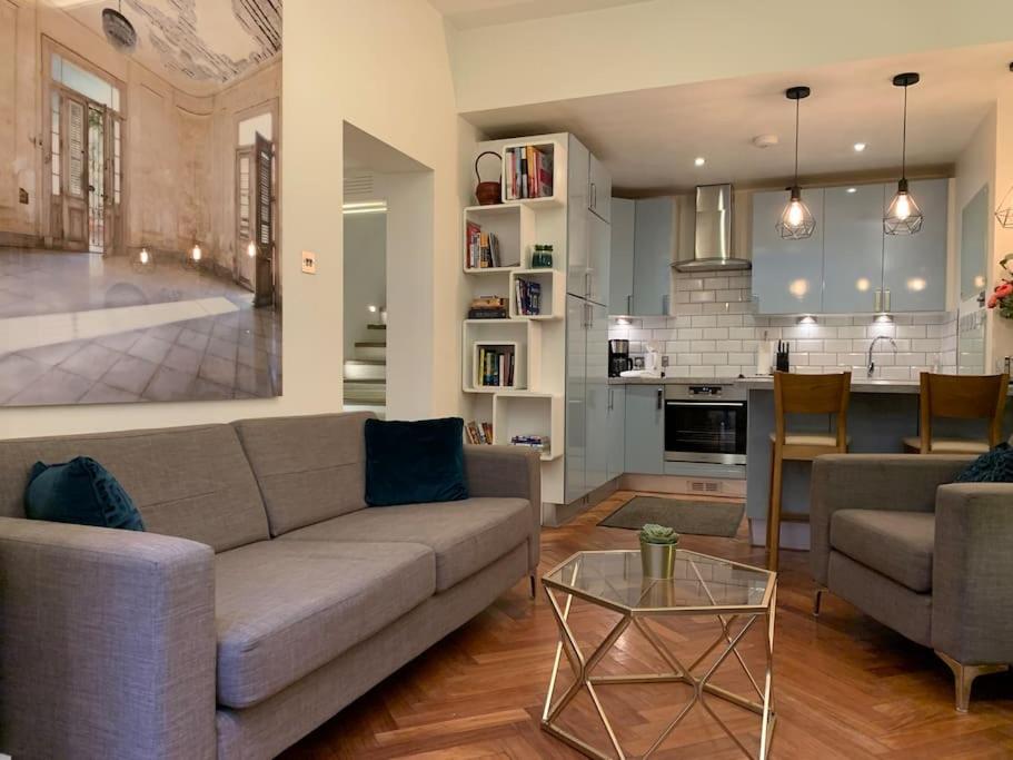 un soggiorno con divano e tavolo e una cucina di Hyde Park 3bed with patio as seen on TV House Hunters International a Londra