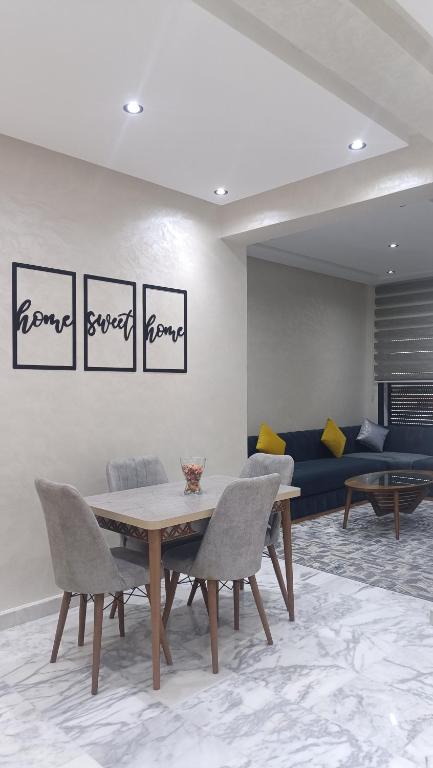 a dining room with a table and chairs and a couch at Escalade BAYTI 2 in El Jadida