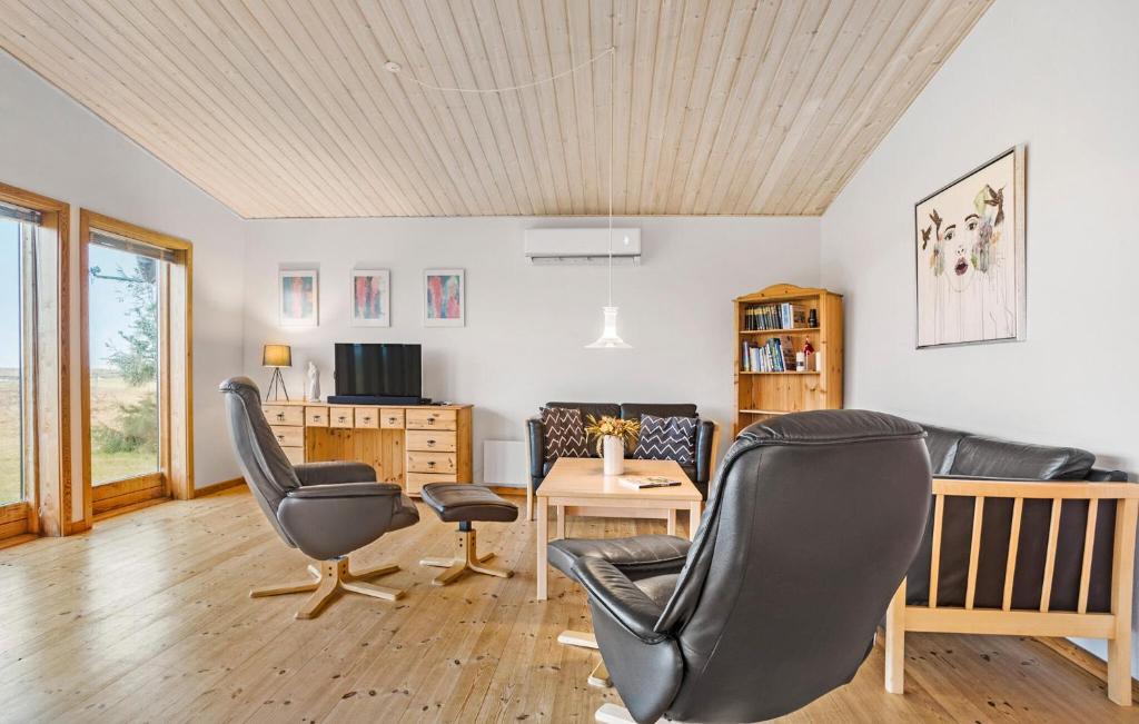 ein Wohnzimmer mit 2 Stühlen und einem Tisch in der Unterkunft 3 Bedroom Lovely Home In Thyholm in Thyholm