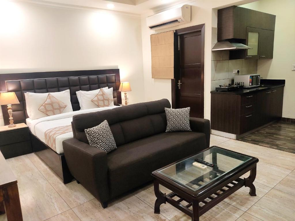 uma sala de estar com um sofá e uma cama em When In Gurgaon - ARTEMIS HOSPITAL 1 Min Walk, FORTIS & MEDANTA 4 Mins Drive em Gurgaon