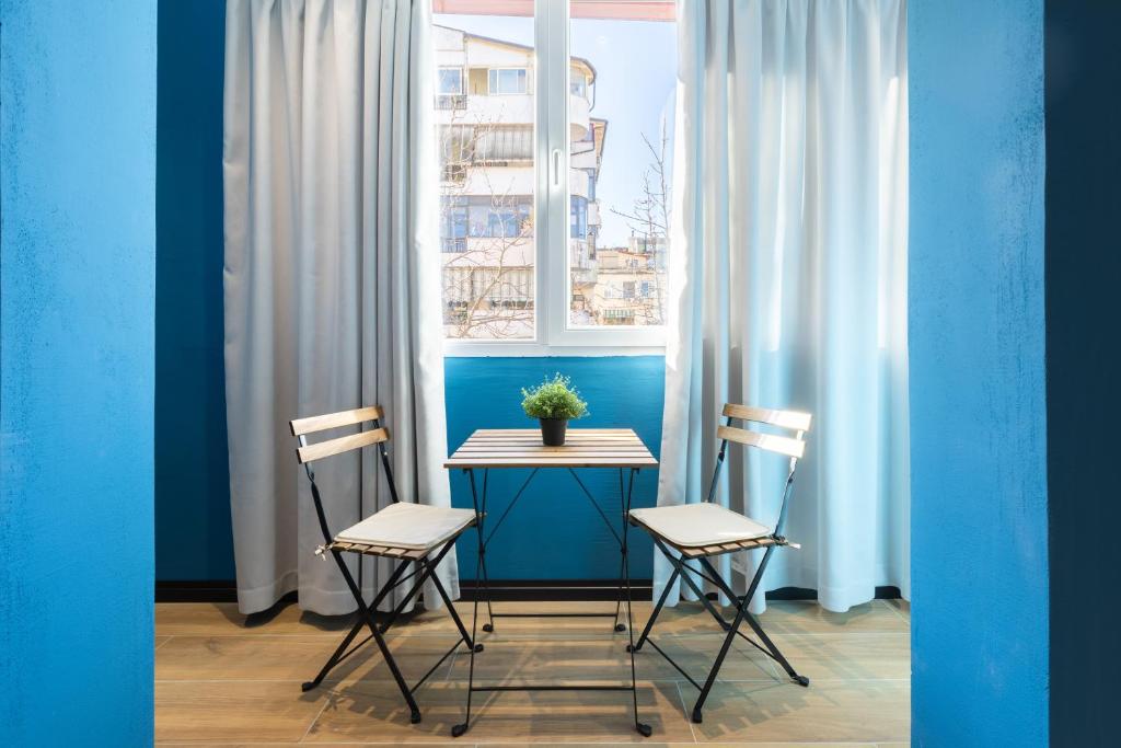 une table et deux chaises devant une fenêtre dans l'établissement UrbanBllok5, à Tirana