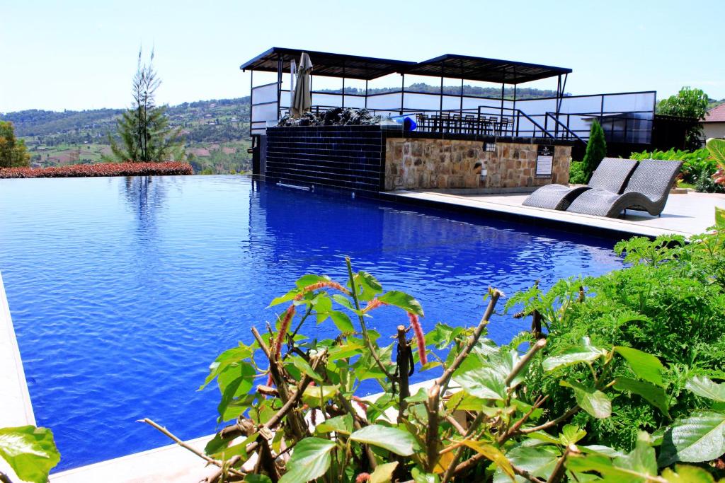 a large swimming pool with chairs and a gazebo at REBERO RESORT Ltd in Kigali