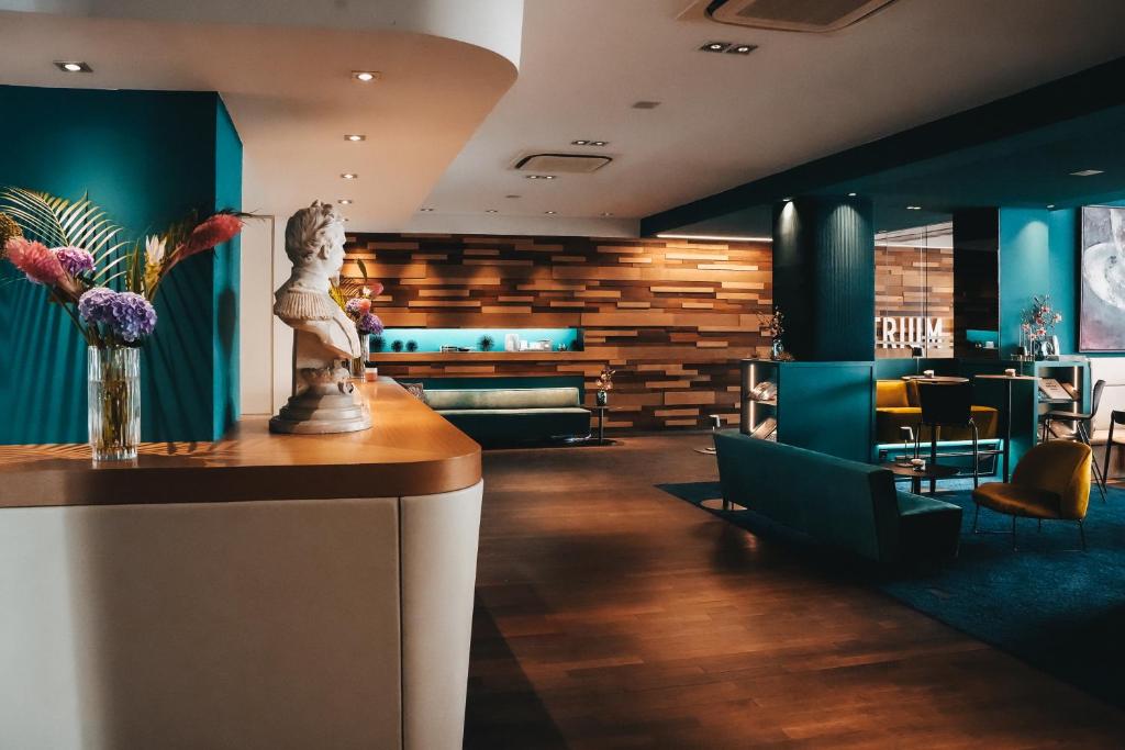 um lobby com uma mesa com uma estátua em Boutique Hotel Atrium München em Munique