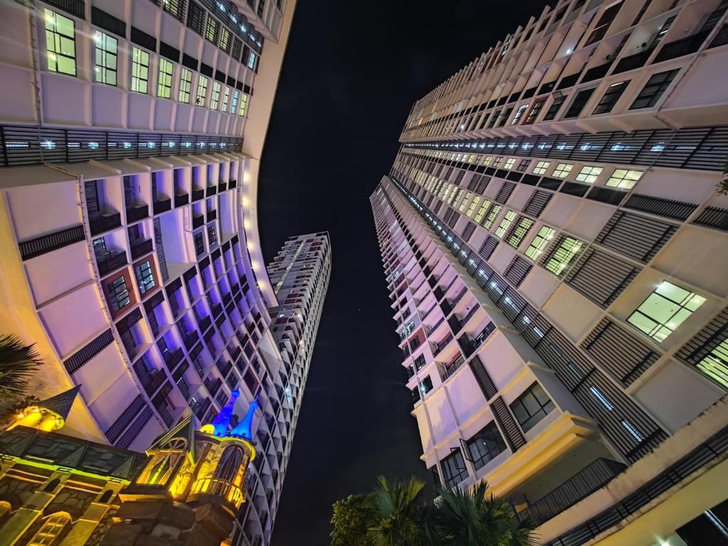 a view of two tall buildings at night at Wan's Homestay i-City in Shah Alam