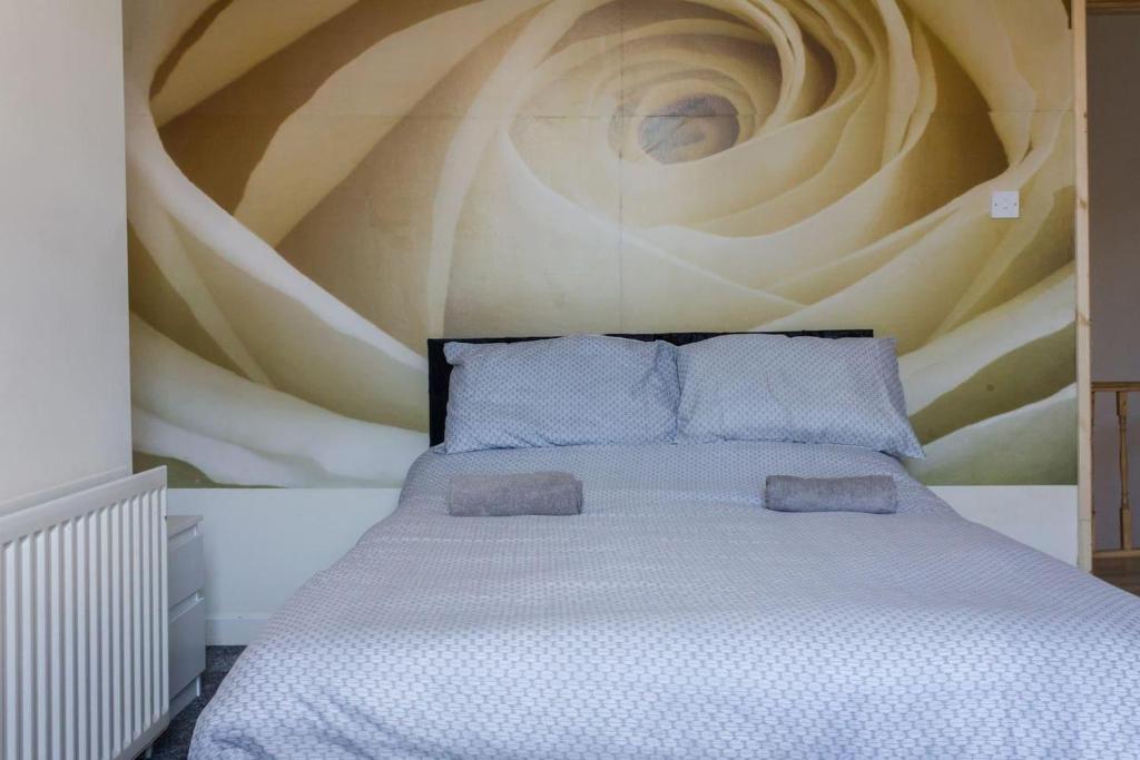 a bedroom with a bed with a painting on the wall at Beautiful 4-Bed House in Bootle in Bootle