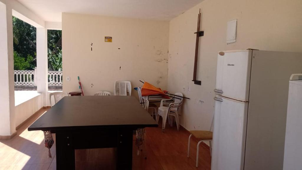 Il comprend une cuisine équipée d'un réfrigérateur, d'une table et de chaises. dans l'établissement Chácara nossa senhora Aparecida, à Suzano