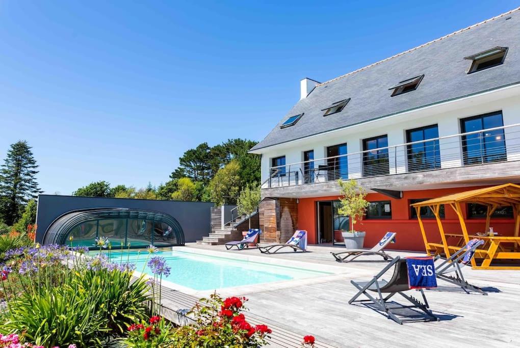 une maison avec une piscine à côté d'un bâtiment dans l'établissement Villa KalonBreizh, Piscine privée chauffée & Sauna, à Plouhinec