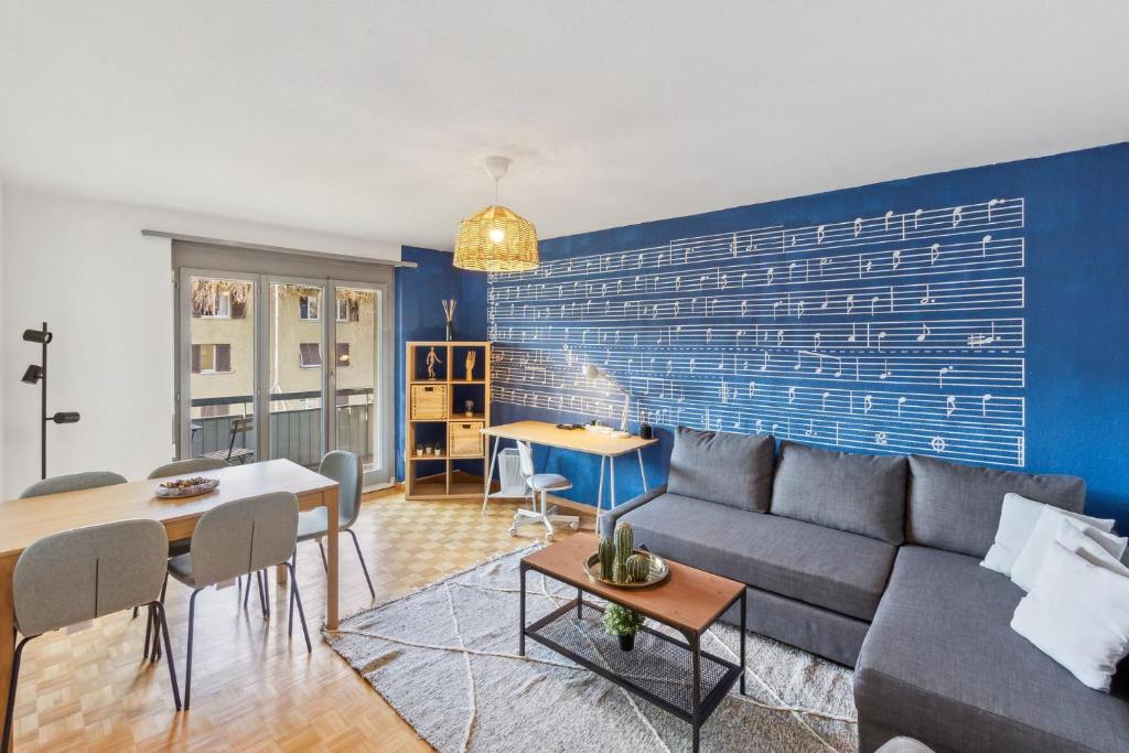 un soggiorno con divano e parete blu di Charming Apartments, Just 27 Minutes to Zurich Center a Zurigo