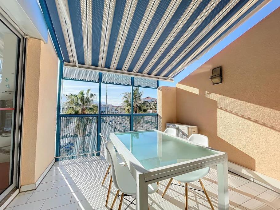 une salle à manger avec une table et des chaises en verre dans l'établissement 3227-Appart 4 personnes climatisé donnant sur le Port Argeles, à Argelès-sur-Mer