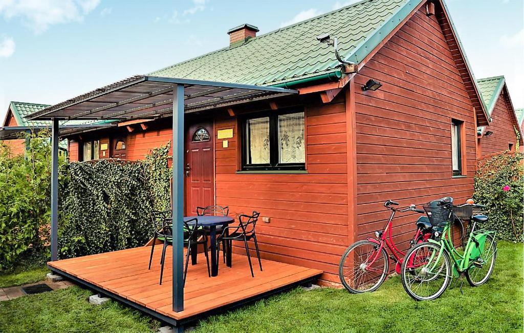 uma pequena casa com uma mesa e duas bicicletas num deque em Cozy Home In Rewal With Wi-fi em Rewal