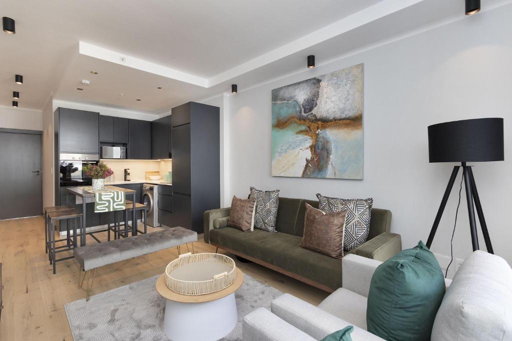 een woonkamer met een bank en een tafel bij Portswood 103 by Host Agents in Kaapstad