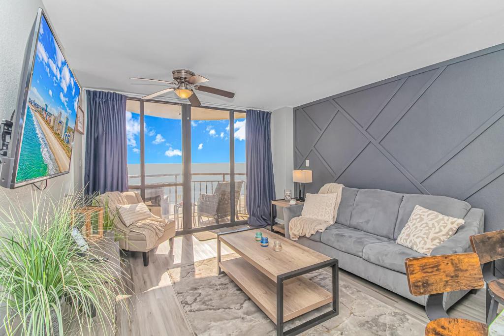 ein Wohnzimmer mit Sofa und Tisch in der Unterkunft Breathtaking Oceanfront Double Queen Suite! Meridian Plaza 701 - Perfect for 4 guests! in Myrtle Beach