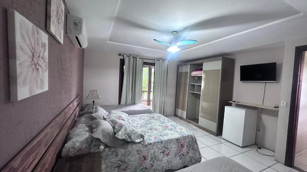 1 dormitorio con 1 cama y ventilador de techo en Do Maraja, en Búzios