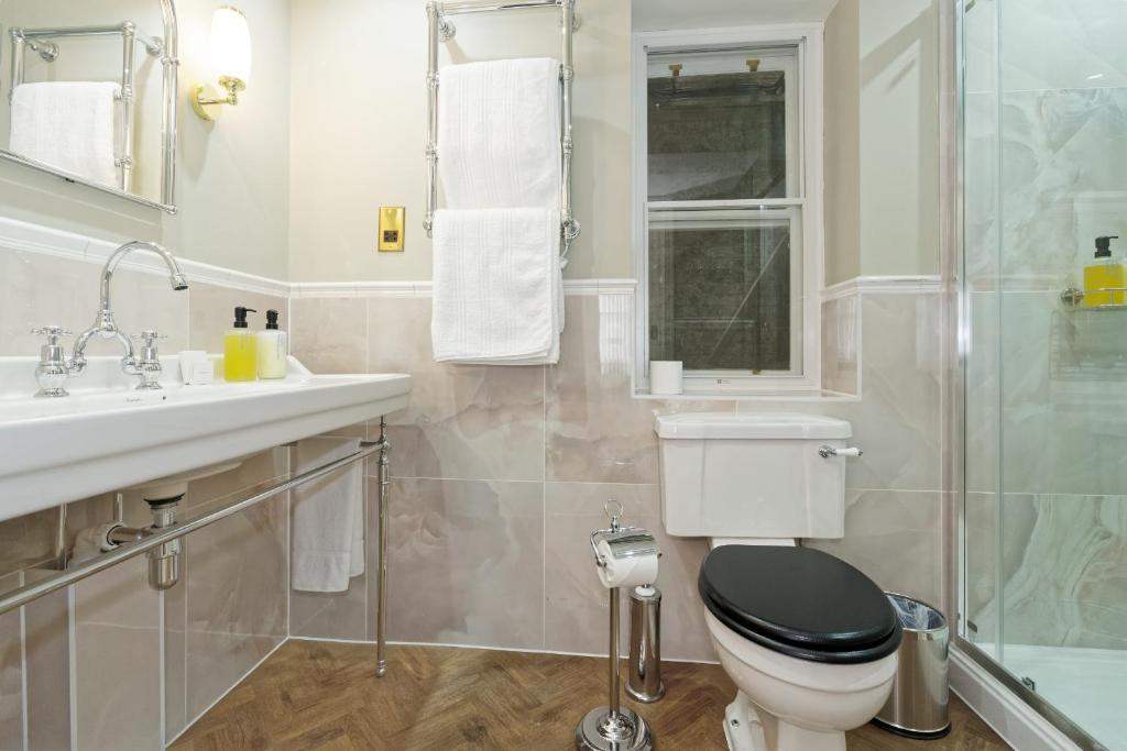 a bathroom with a toilet and a sink and a shower at Old Town House by Ezestays in Margate