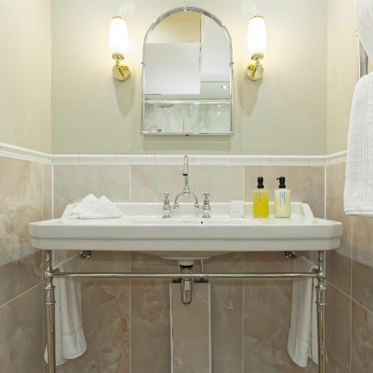 a bathroom with a sink and a mirror at Old Town House by Ezestays in Margate