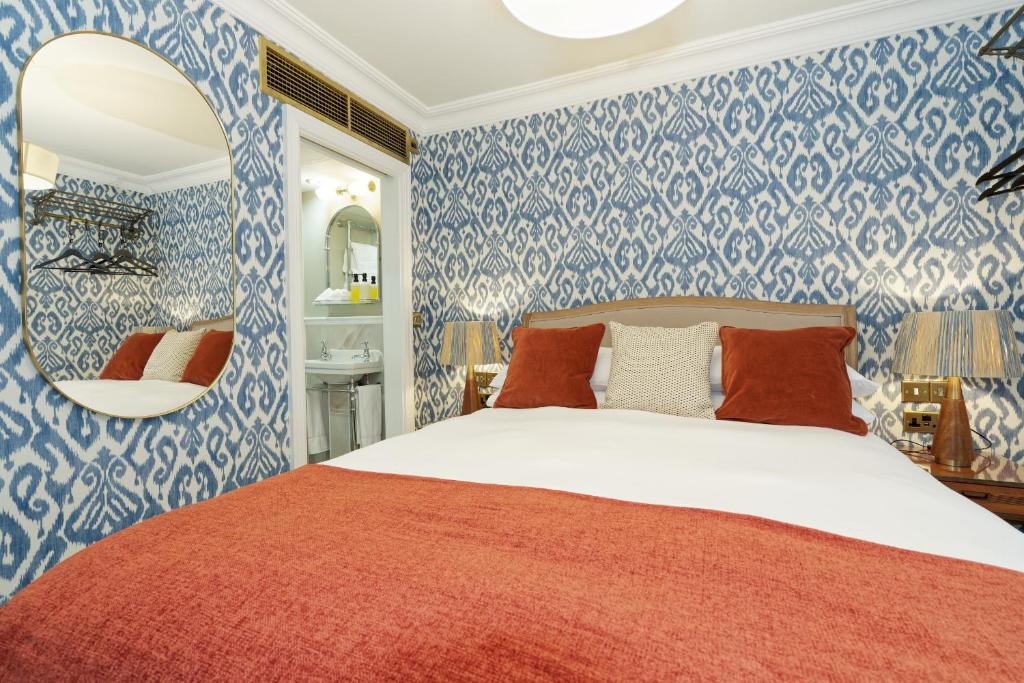 a bedroom with a bed with blue and white wallpaper at Old Town House by Ezestays in Margate