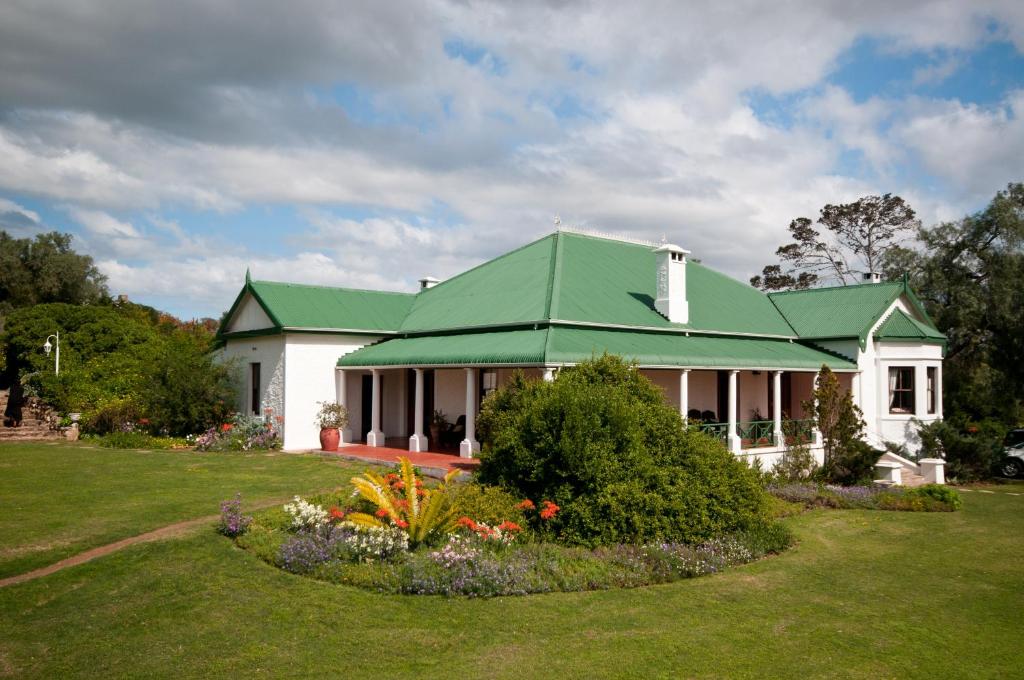 a large white house with a green roof at Leeuwenbosch Country House - Amakhala Game Reserve in Amakhala Game Reserve