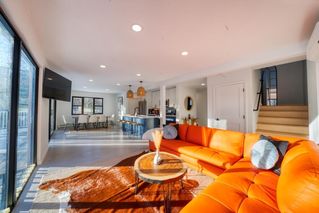 - un canapé orange dans le salon avec une table dans l'établissement Brand New House with Huge Patio, à Kerhonkson