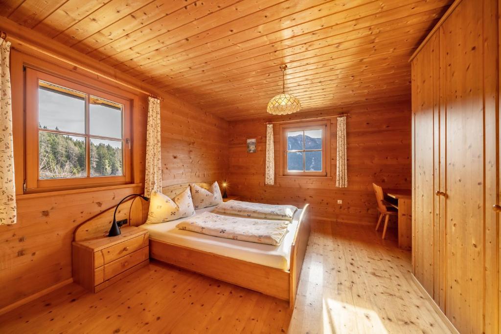 a bedroom with a bed in a wooden cabin at Thalhof Laugen in Ultimo