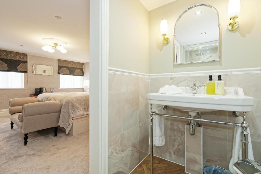 a bathroom with a sink and a mirror and a bed at Old Town House by Ezestays in Margate
