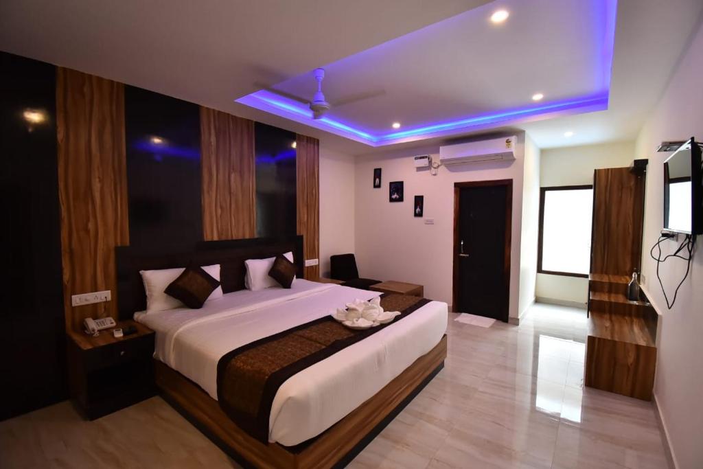 a bedroom with a large bed and a tv in it at SRI KPN HOTEL in Port Blair