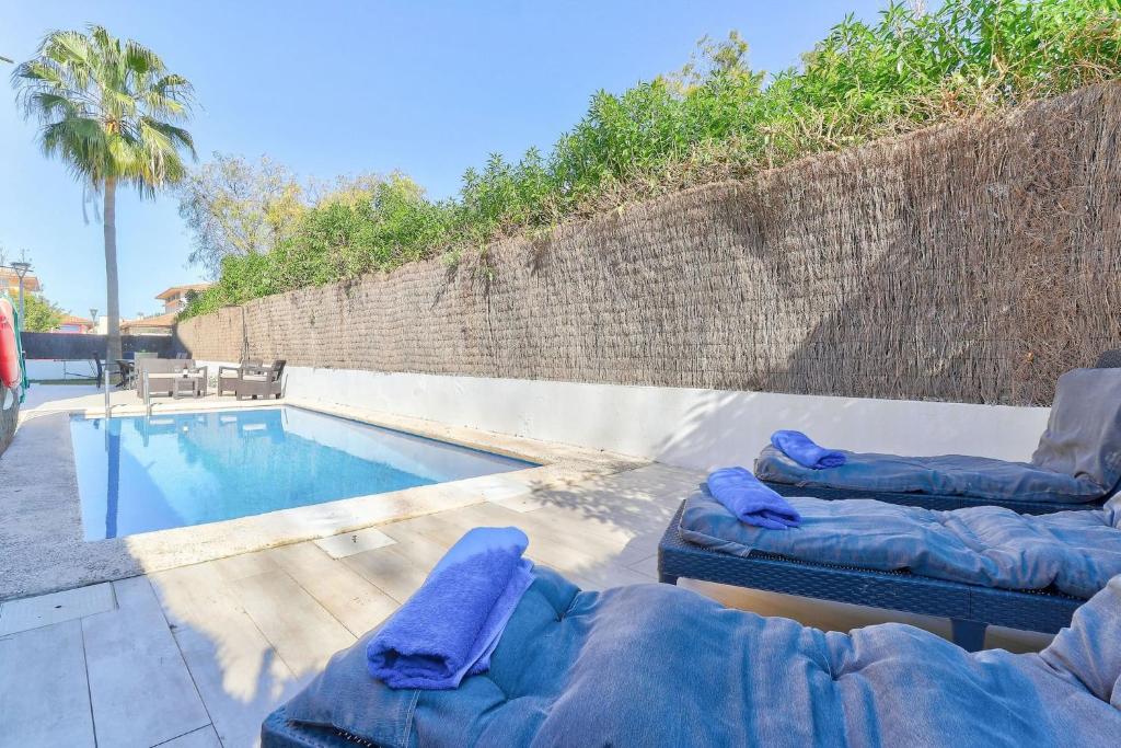 - une piscine avec 2 chaises longues à côté de la piscine dans l'établissement Orquidia by Rentallorca - Private pool and Garden, à Port d'Alcúdia