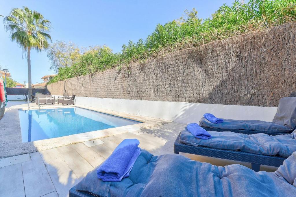 una piscina con due sedie a sdraio accanto a una piscina di Orquidia by Rentallorca - Private pool and Garden a Port d'Alcudia