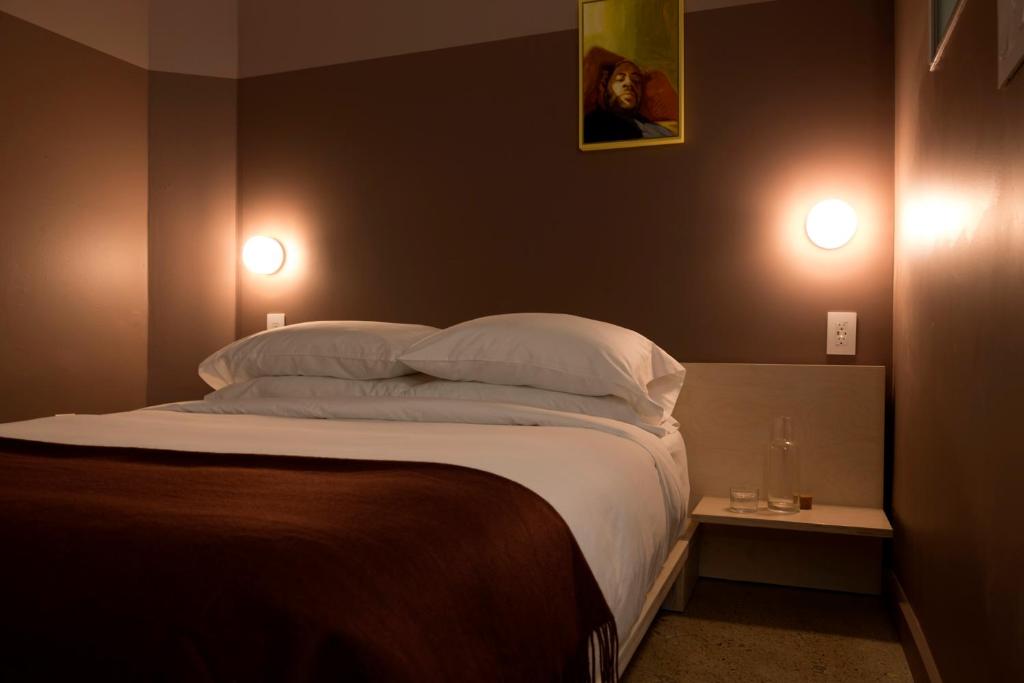 a bedroom with a bed with two lights on the wall at Ode in Toronto