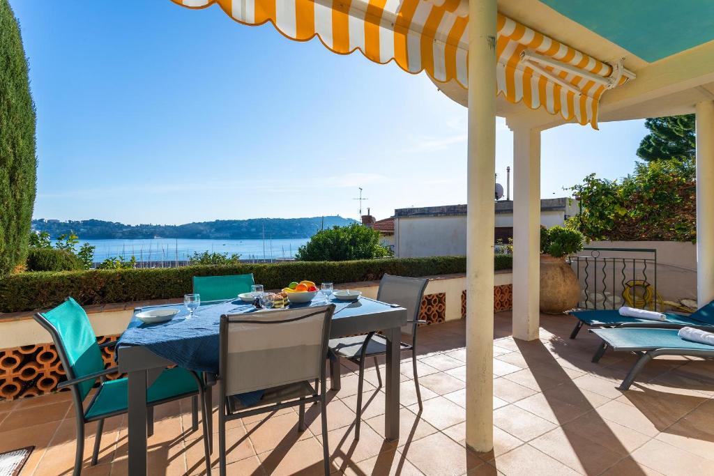a table and chairs on a patio with a view at LA MALMAISON AP1064 Villefranche-sur-Mer, by RIVIERA HOLIDAY HOMES in Villefranche-sur-Mer