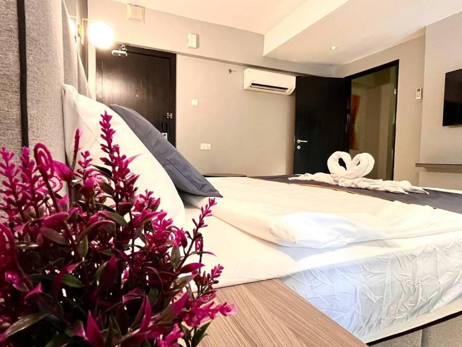 um quarto com uma cama grande com flores roxas em HillLand Suites em Ayer Keroh