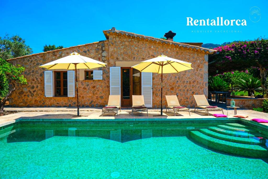 una casa y una piscina con 2 sombrillas y sillas en Finca Ca'n Sec by Rentallorca, en Sóller