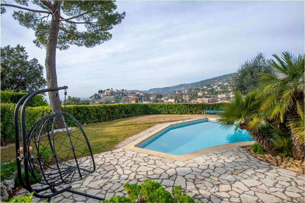 - une piscine dans un jardin avec une balançoire à côté dans l'établissement La Joliette - Parking privé et piscine partagée, à Cabris