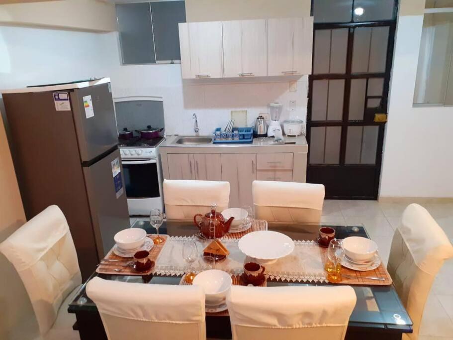 eine Küche mit Tisch und Stühlen und eine Küche mit Kühlschrank in der Unterkunft Sweet House in Huaraz