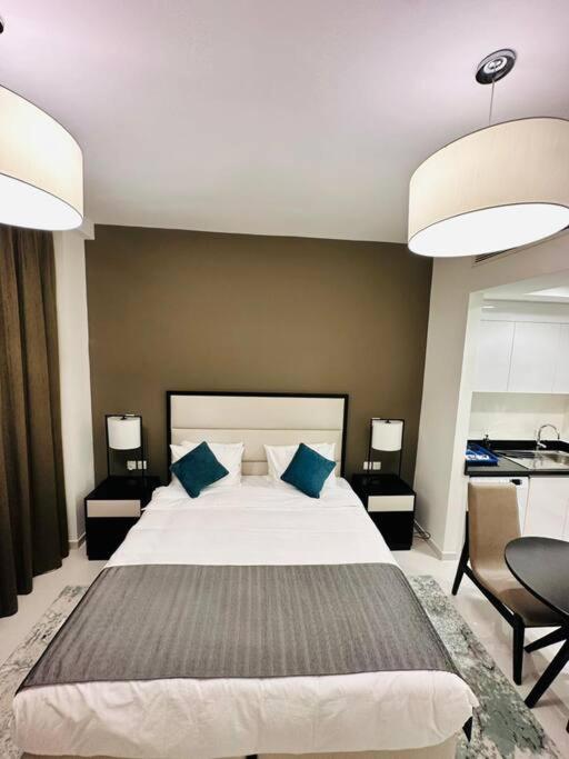 ein Schlafzimmer mit einem großen Bett mit blauen Kissen in der Unterkunft Charming city apartment in Dubai