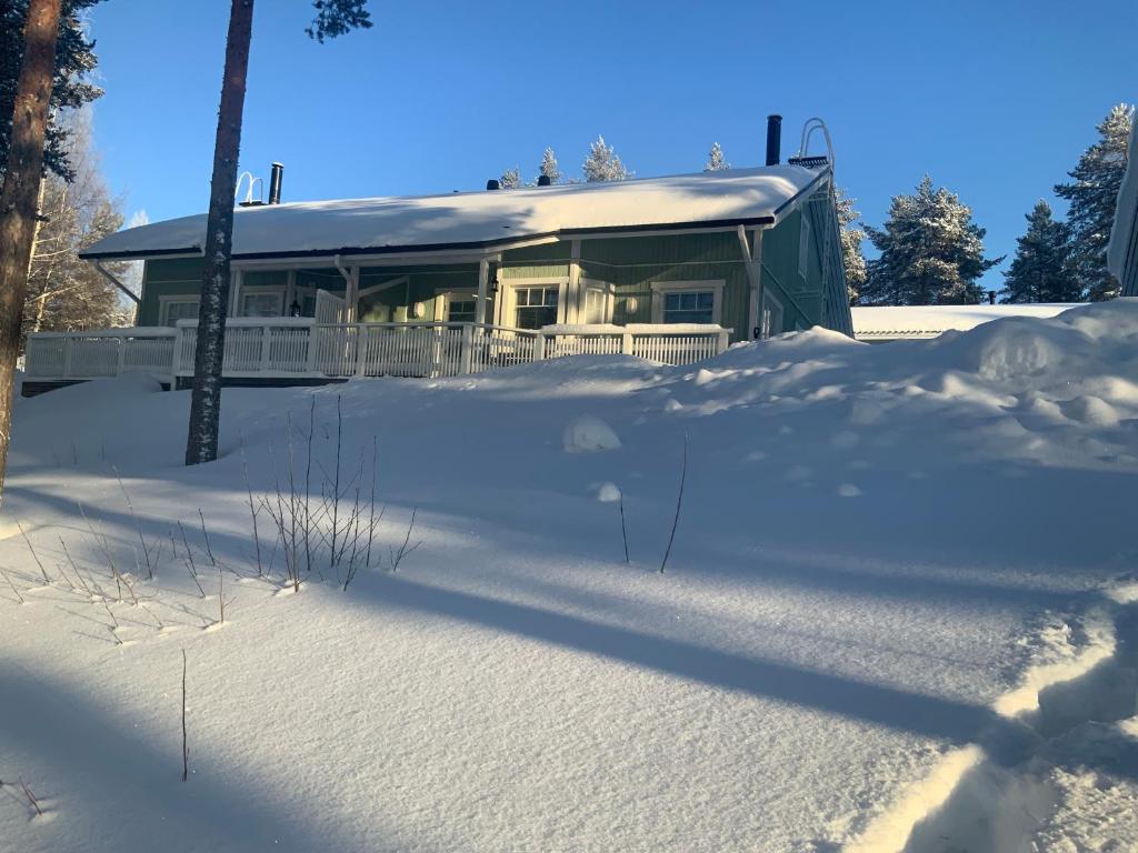 une maison recouverte de neige devant dans l'établissement Saunaharju 5 järven rannalla, à Kolinkylä