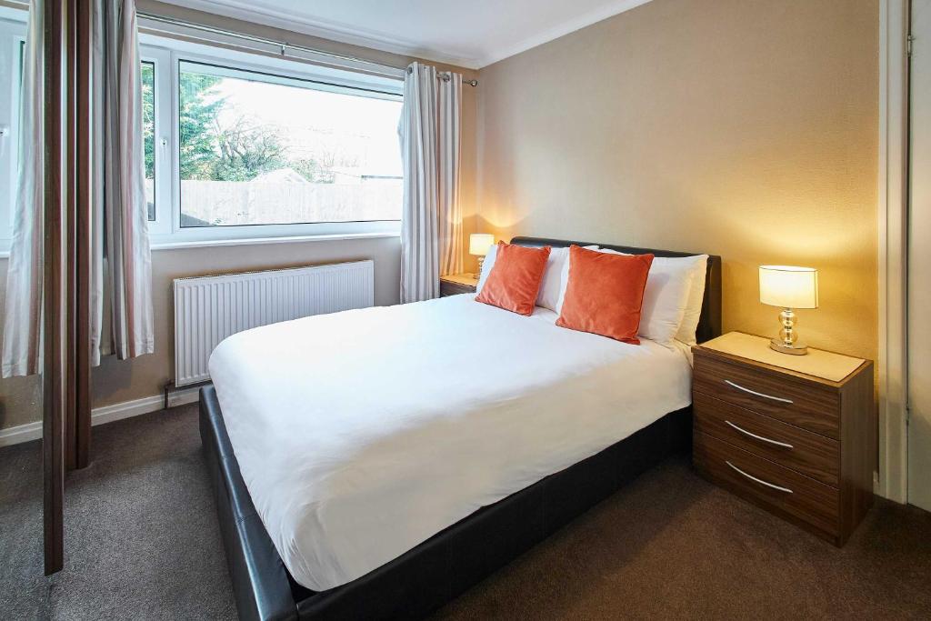 a bedroom with a bed with orange pillows and a window at Host & Stay - Spring Gardens in Cayton